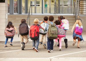 Kinderen met rugzakken, op de rug gezien